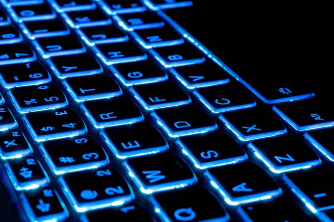 blue illumination of the notebook keyboard. Technology concept.