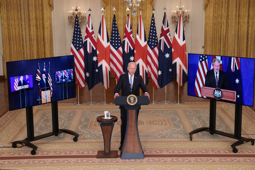 Joe Biden em declaração à imprensa na Casa Branca, acompanhado por monitores que mostravam ao vivo os primeiros-ministros da Austrália, Scott Morrison, e do Reino Unido, Boris Johnson - 15/09/2021