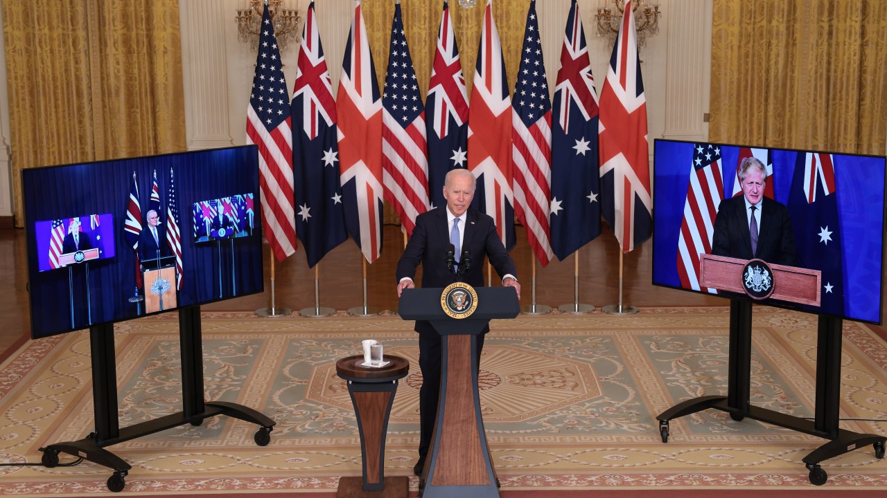 Joe Biden em declaração à imprensa na Casa Branca, acompanhado por monitores que mostravam ao vivo os primeiros-ministros da Austrália, Scott Morrison, e do Reino Unido, Boris Johnson - 15/09/2021