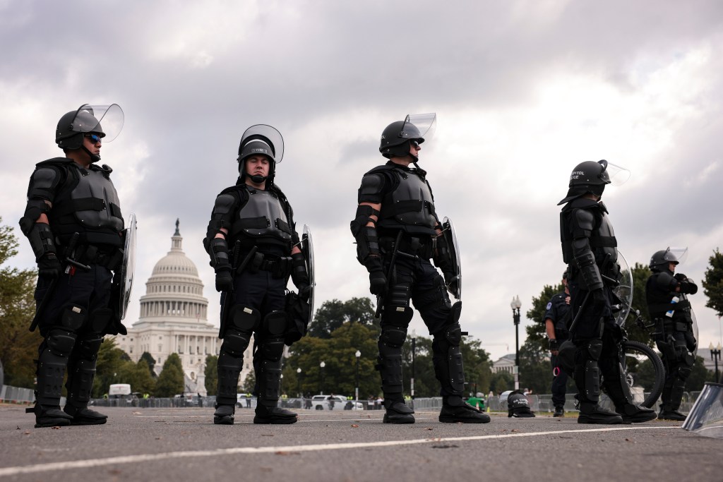 Policiais cercam o Capitólio, em Washington, neste sábado (18)