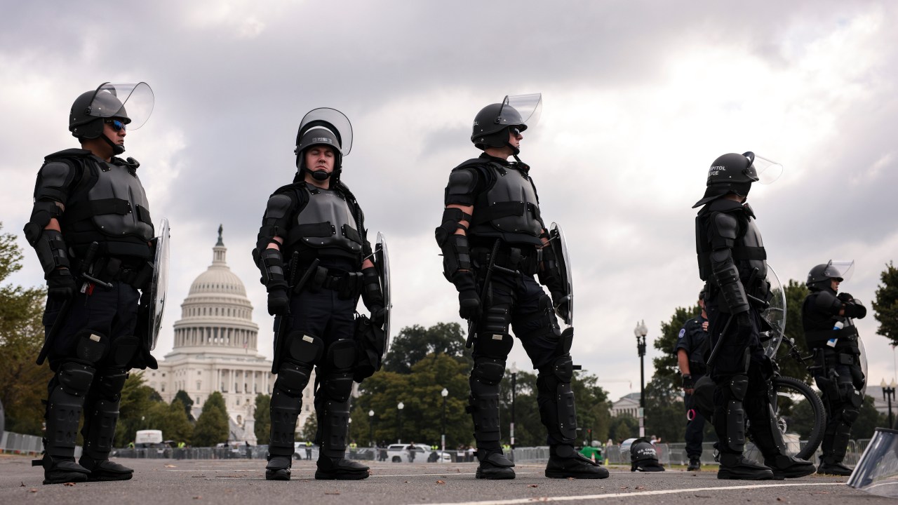 Policiais cercam o Capitólio, em Washington, neste sábado (18)