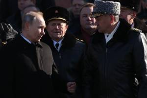 Vladmir Putin aperta a mão do general Sergey Shoigu, em evento realizado em Moscou em 2018