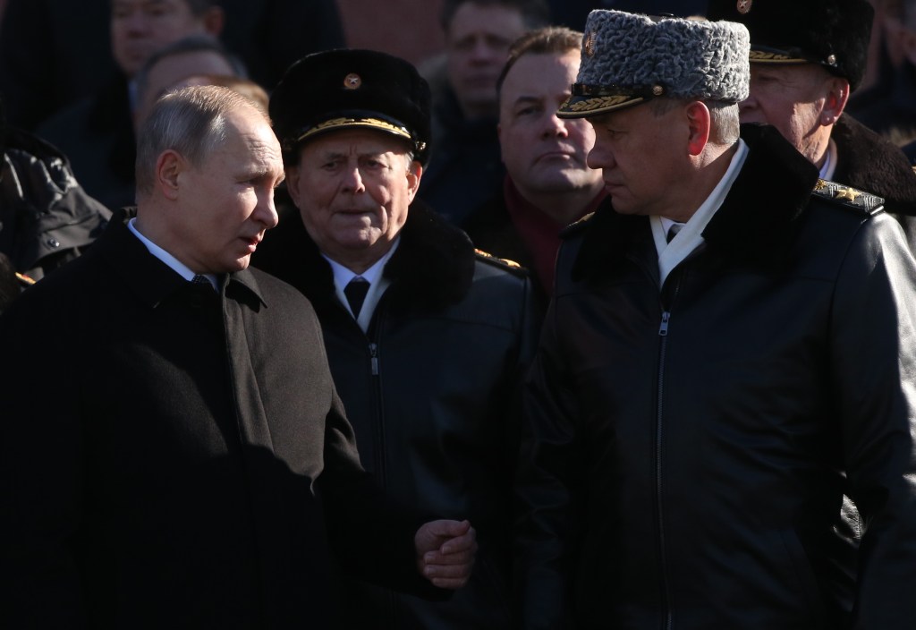 Vladmir Putin aperta a mão do general Sergey Shoigu, em evento realizado em Moscou, em 2018