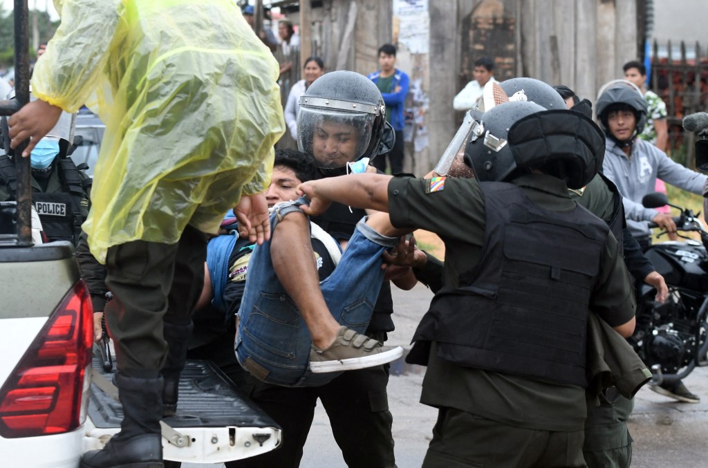 Policial segura homem durante manifestação em Santa Cruz, Bolívia. 11/10/2021