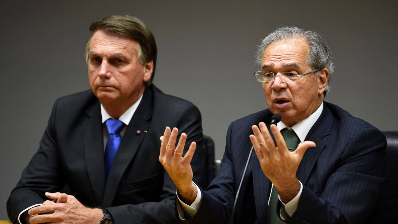 razilian President Jair Bolsonaro (L) and his Economy Minister Paulo Guedes (R) are seen during a press conference at the Ministry of Economy headquarters in Brasilia, on October 22, 2021. (Photo by EVARISTO SA / AFP)