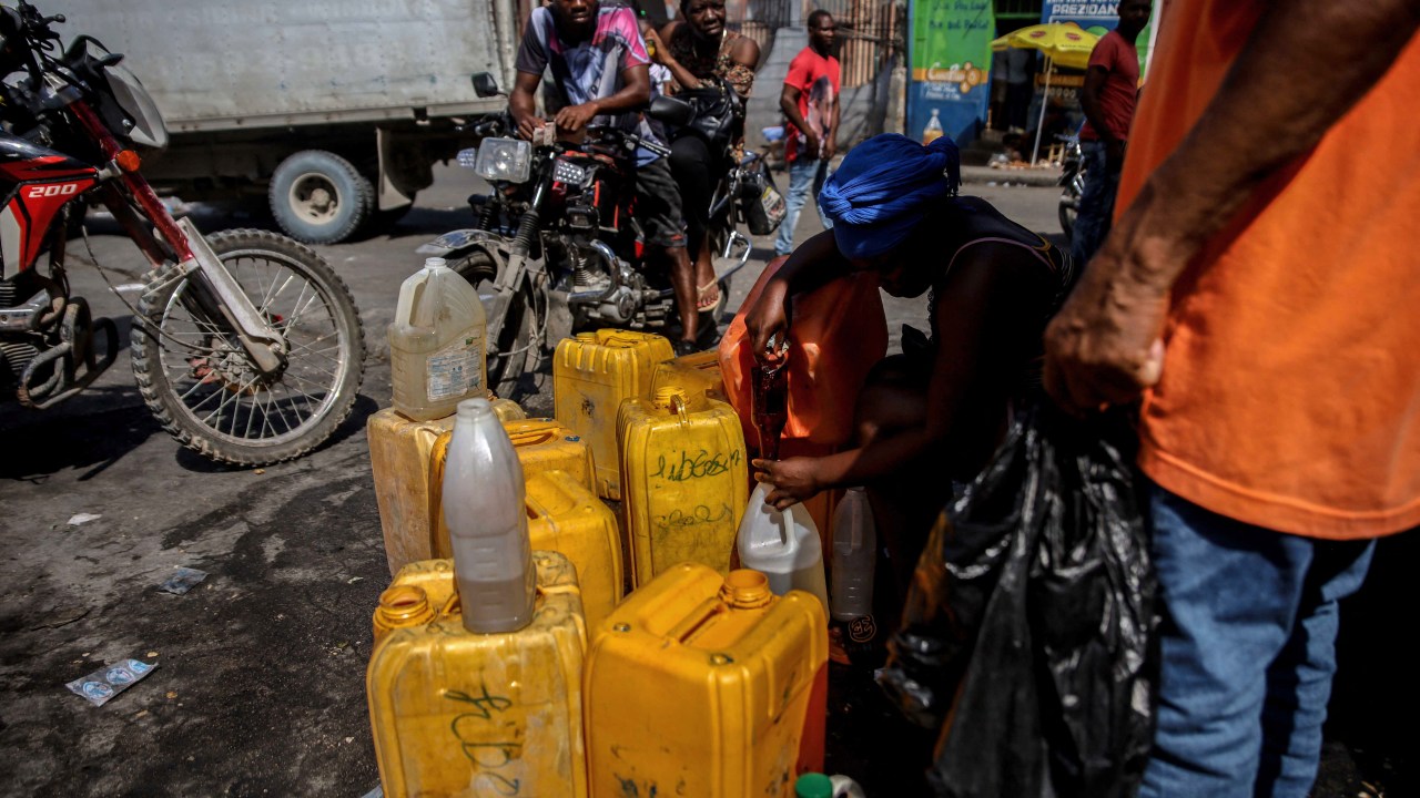 Mulher vende combustível em Porto Príncipe em meio a bloqueio promovido por gangues no Haiti. 26/10/2021
