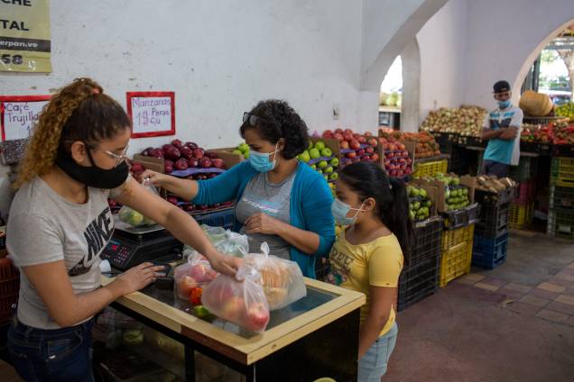 Mulher durante compra de verduras em Caracas -