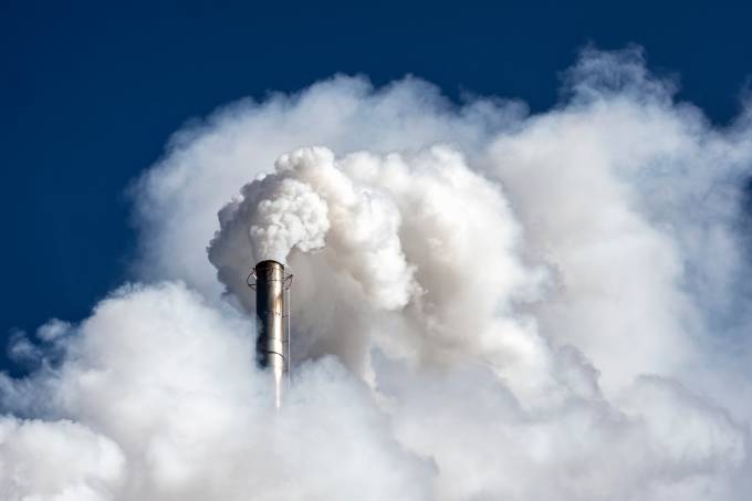 Industrial factory chimney emitting smoke and gas pollution into the atmosphere.