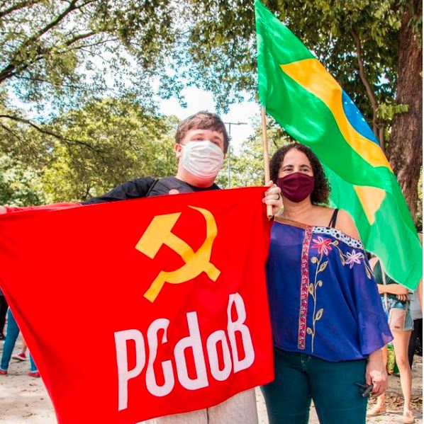 A vice-governadora do Recife, Luciana Santos, posa com a bandeira brasileira e a do seu partido, o PCdoB