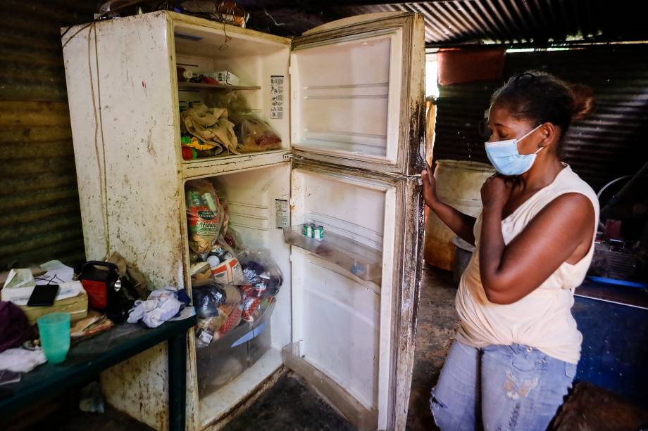 Mulher mostra a sua geladeira em uma casa na zona rural de Tocorón, estado de Miranda -