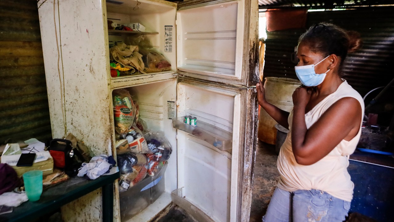 Mulher mostra a sua geladeira em uma casa na zona rural de Tocorón, estado de Miranda -