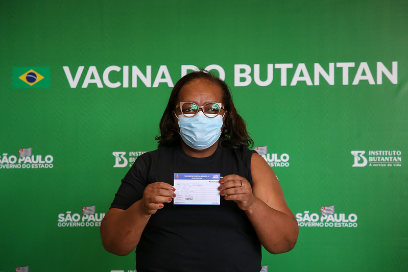 A enfermeira Mônica Calazans, primeira a ser vacinada no país contra a Covid-19, mostra carteira de vacinação após tomar dose de reforço