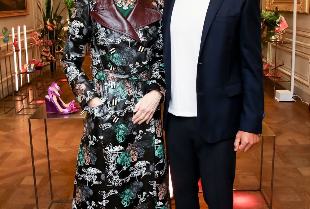 A imagem mostra Anna Wintour, de vestido longo estampado, ao lado de Alexandre Birman