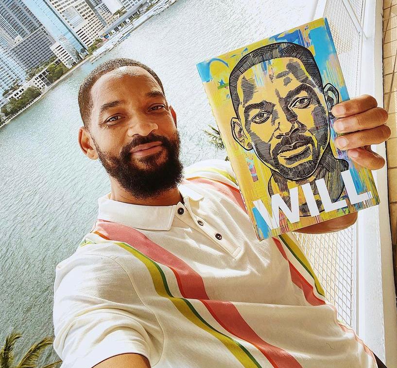 Will Smith mostrando a capa de seu livro de memórias