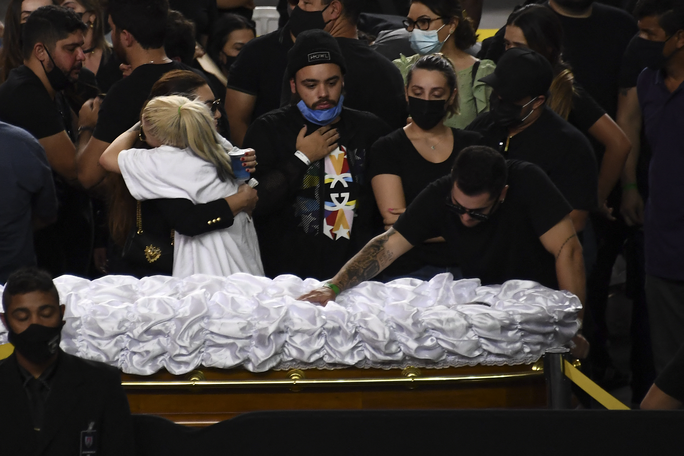 Relatives and friends mourn next to the coffin of Brazilian singer Marilia Mendonca, during her wake at the Arena Goiania sports centre, in Goiania, state of Goias, Brazil, on November 6, 2021. - Marilia Mendonca, 26, one of the most popular of the 
