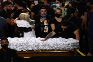 Relatives and friends mourn next to the coffin of Brazilian singer Marilia Mendonca, during her wake at the Arena Goiania sports centre, in Goiania, state of Goias, Brazil, on November 6, 2021. - Marilia Mendonca, 26, one of the most popular of the "sertanejo" genre in Brazil and a Latin Grammy winner, died on the eve along with four other people in an airplane crash on her way to a concert, in the state of Minas Gerais. (Photo by EVARISTO SA / AFP)