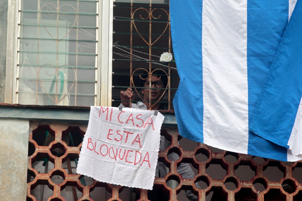 Opositor cubano Yunior García mostra cartaz escrito "minha casa está bloqueada", em Havana. 14/11/2021