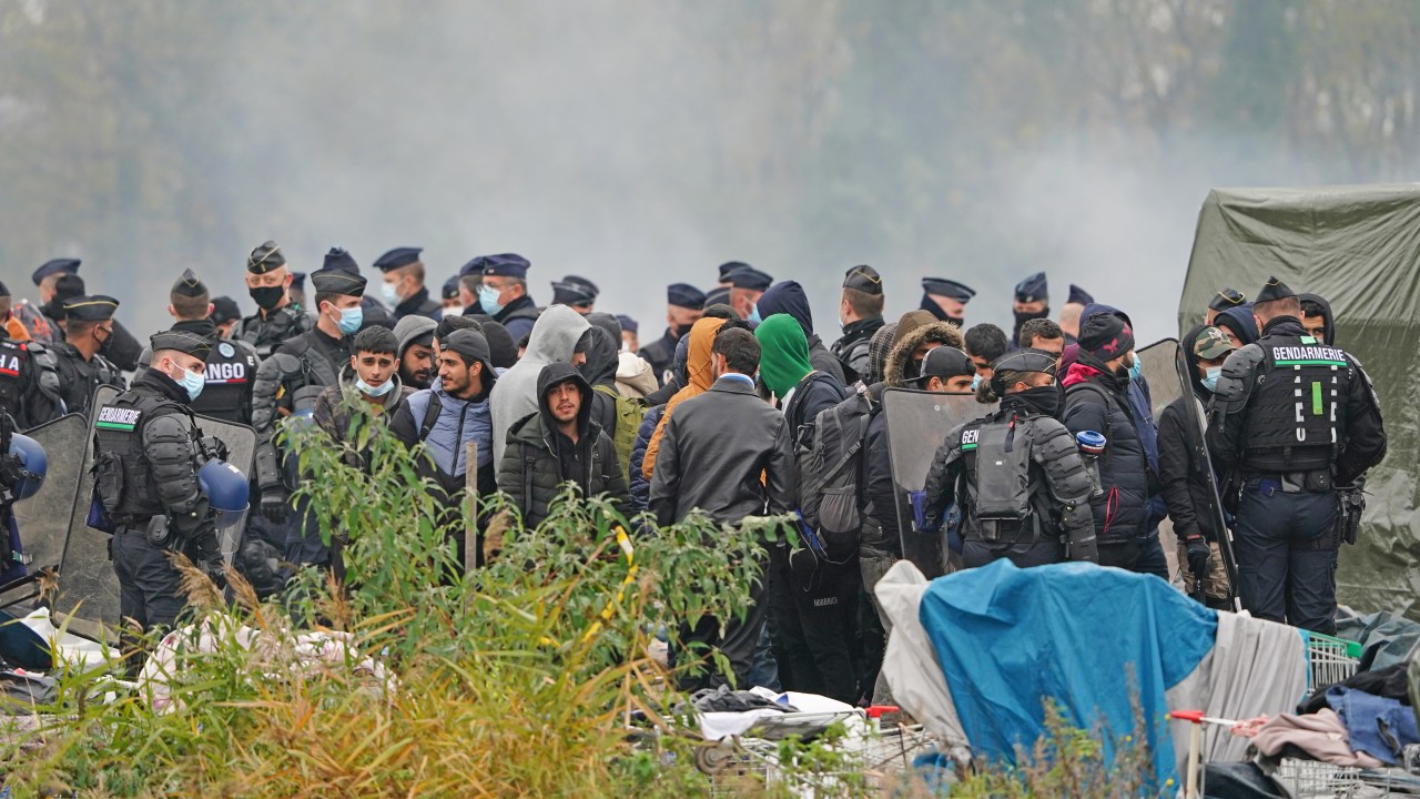 Migrants at a makeshift camp on the site of a former industrial complex in Grande-Synthe, east of Dunkirk, as French police are evacuating migrants from the site, where at least 1,500 people had gathered in hopes of making it across the English Channel to Britain. Picture date: Tuesday November 16, 2021. (Photo by Gareth Fuller/PA Images via Getty Images)
