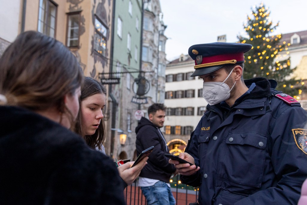 Policial checa comprovantes de vacinação em Innsbruck, Áustria