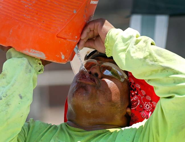 Trabalhador se hidrata durante onda de calor em Phoenix, nos Estados Unidos