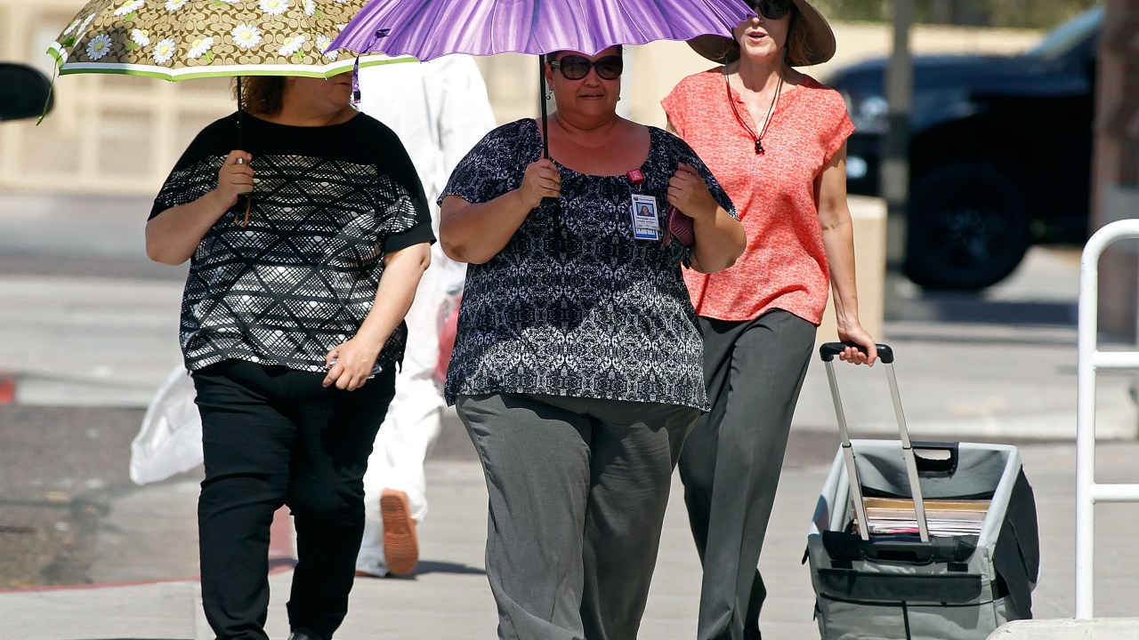 Durante onda de calor em Phoenix, nos Estados Unidos, pedestres precisam se proteger do sol
