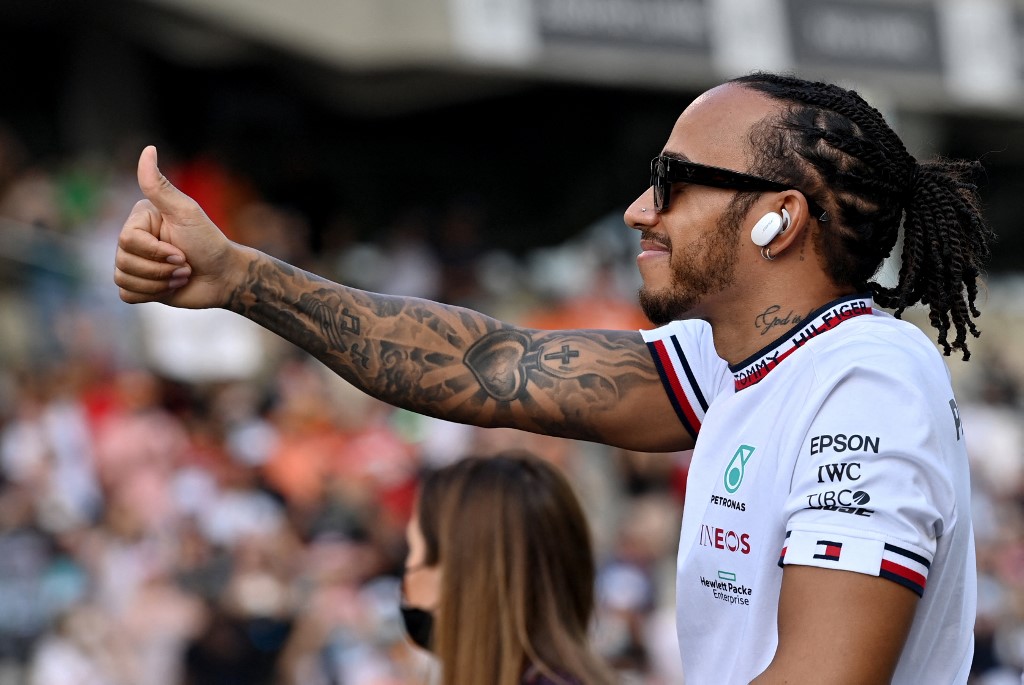 Mercedes' British driver Lewis Hamilton waves to the ground during the drivers' parade at the Yas Marina Circuit before the Abu Dhabi Formula One Grand Prix on December 12, 2021
