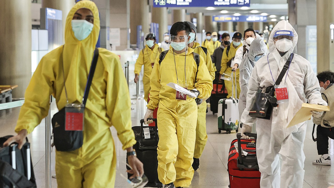 PROTEÇÃO - Figurino de viagem: na Coreia do Sul, passageiros usam roupa especial para afastar o risco de infecção pela cepa -