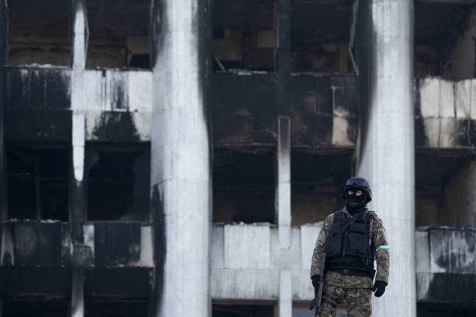 Militar patrulha prédio do governo destruído por manifestantes nesta quarta-feira (12) na cidade de Almaty