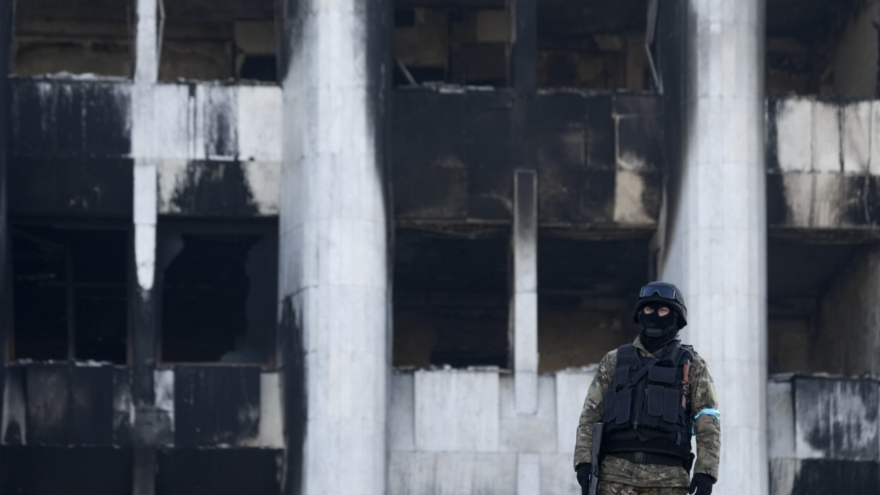 Militar patrulha prédio do governo destruído por manifestantes nesta quarta-feira (12) na cidade de Almaty, no Cazaquistão