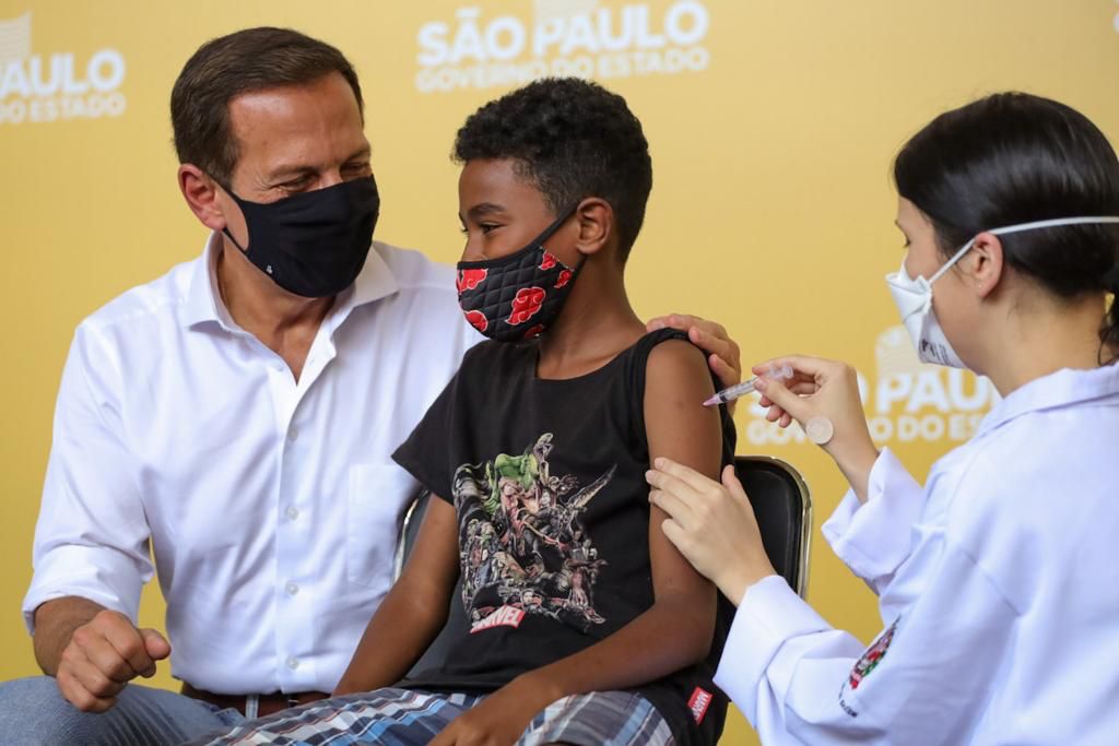 João Doria ao lado de criança vacinada com a CoronaVac
