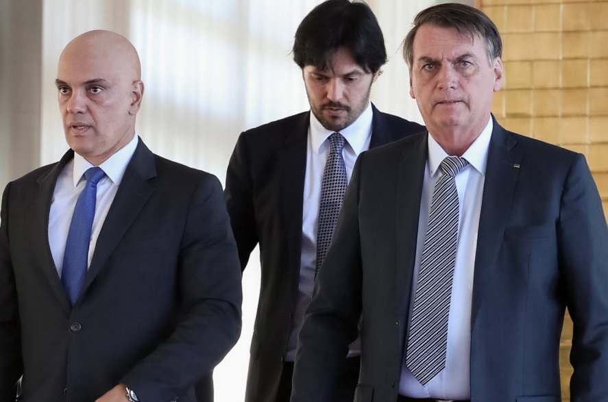 O ministro do STF Alexandre de Moraes e o presidente Jair Bolsonaro; ao fundo, o ministro das Comunicações Fábio Faria