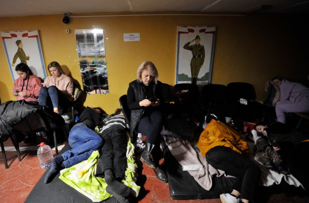 Pessoas se escondem em um abrigo antiaéreo em Kiev, nas primeiras horas do dia 25 de fevereiro de 2022 -