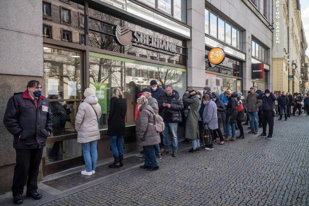 Pessoas fazem fila do lado de fora de uma agência do banco estatal russo Sberbank para retirar suas economias e fechar suas contas, em Praga, na República Tcheca -