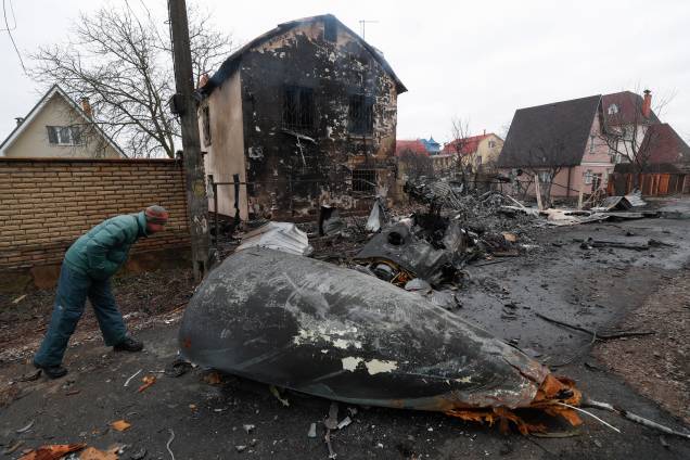 Um homem observa os destroços de um avião militar que foi abatido durante a noite em Kiev -