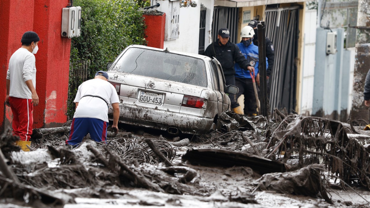 QUITO, ECUADOR - FEBRUARY 01: People and relief organizations clean the streets during the rescue efforts after a landslide was caused by heavy rains on February 1, 2022 in Quito, Ecuador. At least 18 people have been confirmed killed by the landslide caused yesterday by heavy rains in Quito. The floods are considered the heaviest in two decades; authorities report 16 people missing and over 40 injured. (Photo by Felipe Stanley/Agencia Press South/Getty Images)