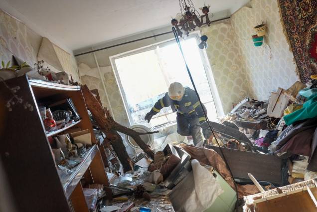 Bombeiros ucranianos chegam para resgatar civis após um ataque aéreo atingir um complexo de apartamentos em Chuhuiv, na Ucrânia -