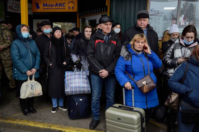 Pessoas esperam ônibus em uma estação enquanto tentam evacuar da cidade de Kiev, na Ucrânia -