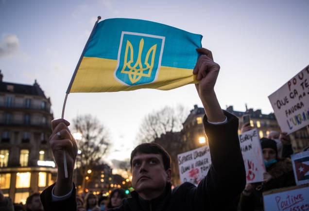 Um manifestante segura uma bandeira ucraniana enquanto cidadãos ucranianos e franceses se reúnem na Praça da República, em Paris -