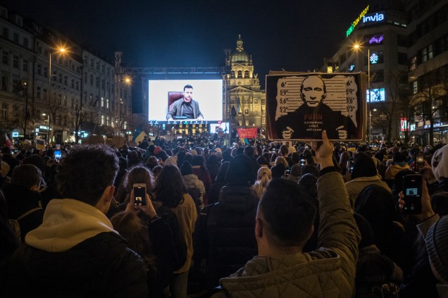 Manifestantes ouvem um discurso do presidente ucraniano Volodymr Zelensky exibido durante uma manifestação contra a invasão da Ucrânia pela Rússia -