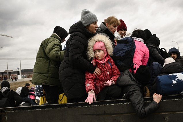 Uma criança observa moradores evacuando a cidade de Irpin, a noroeste de Kiev -