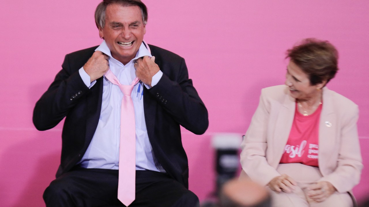Brazilian President Jair Bolsonaro wears a pink tie during a ceremony marking International Women's Day at Planalto Palace, in Brasília, on March 8, 2022. (Photo by Sergio Lima / AFP)