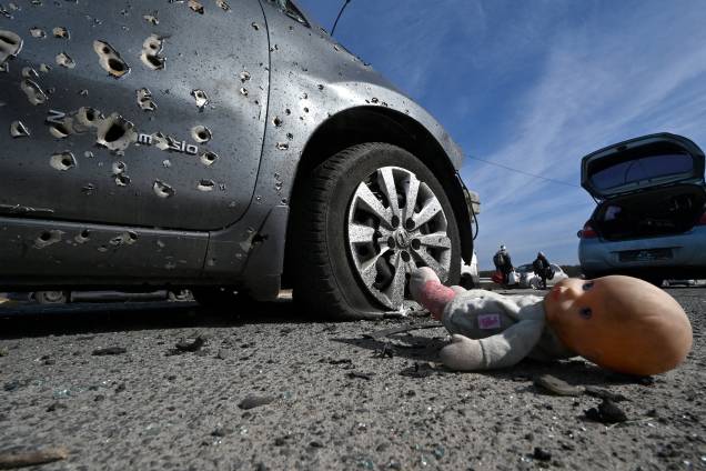Uma boneca abandonada ao lado de um carro crivado de balas em Irpin, ao norte de Kiev -