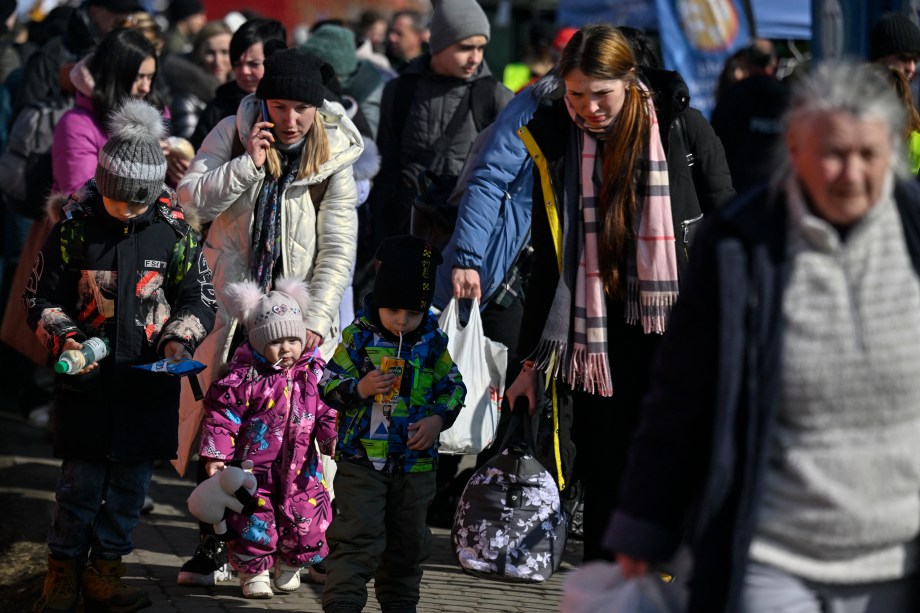 Refugiados da Ucrânia chegam depois de cruzar a fronteira ucraniana com a Polônia, no posto fronteiriço de Medyka, no sudeste polônes -