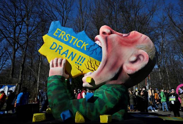 Uma figura gigante representando o presidente russo Vladimir Putin engolindo um mapa da Ucrânia é vista durante uma manifestação contra a invasão da Ucrânia pela Rússia, em Berlim -