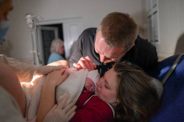 Aleina e seu marido abraçam seu recém-nascido Snizhana após dar à luz na maternidade, enquanto sirenes alertam sobre ataques aéreos em Mykolaiv -