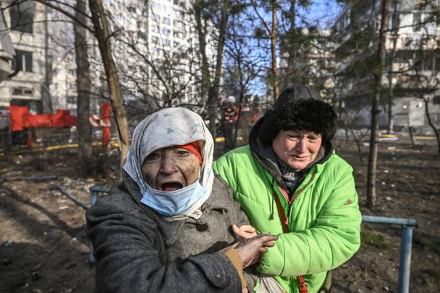 Uma mulher é retirada de um prédio de apartamentos em chamas, em Kiev -