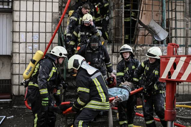 Bombeiros removem o corpo de uma mulher de um prédio de apartamentos destruído em Kiev -