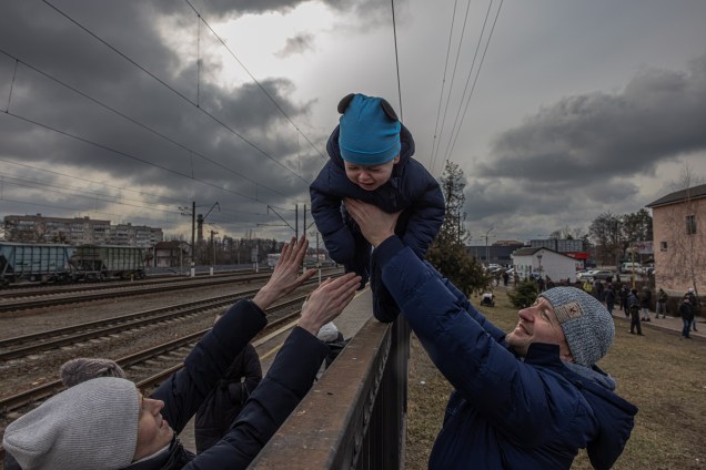 Uma criança observa moradores evacuando a cidade de Irpin, ao noroeste de Kiev -