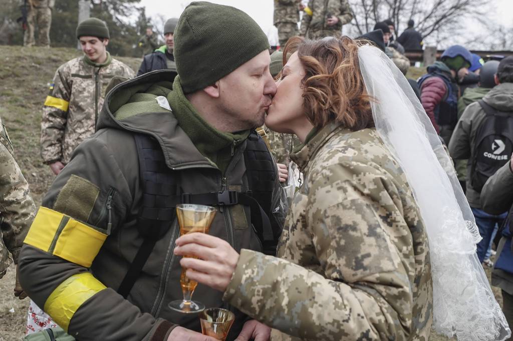 GUERRA E PAZ - Os soldados ucranianos Valeriy e Lesya trocaram as armas pelo champanhe para celebrar a união: amor -