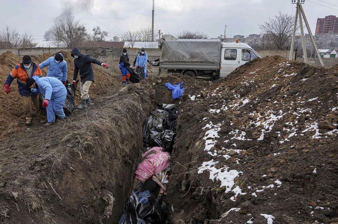 Dead bodies are put into a mass grave on the outskirts of Mariupol, Ukraine, Wednesday, March 9, 2022 as people cannot bury their dead because of the heavy shelling by Russian forces. (AP Photo/Evgeniy Maloletka)